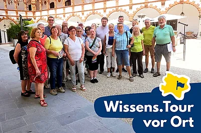Das Bild zeigt eine Gruppe Menschen im Innenhof der Renaissanceburg Schallaburg, wo diese die Ausstellung „Träume träumen“ besuchte.