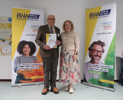 Foto mit 2 Personen, eine der Personen hält eine "80 Jahre BhW" Urkunde.