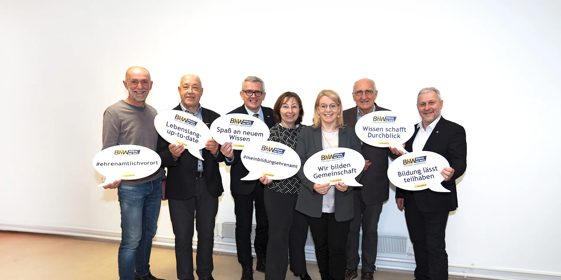 Gruppenbild mit BHW Vorstand. Die Personen halten große Sprechblasen in die Höhe mit einigen Schlagworten zum Tag des Ehrenamtes.