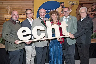 Gruppenbild, die Personen halten das Wort "echt" in den Händen